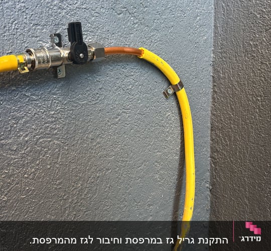 ברז וצינור גז צהוב על קיר אפור